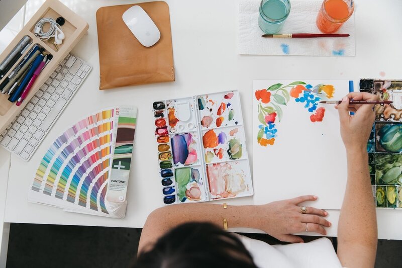 Jenna Rainey at her home studio desk painting loose florals